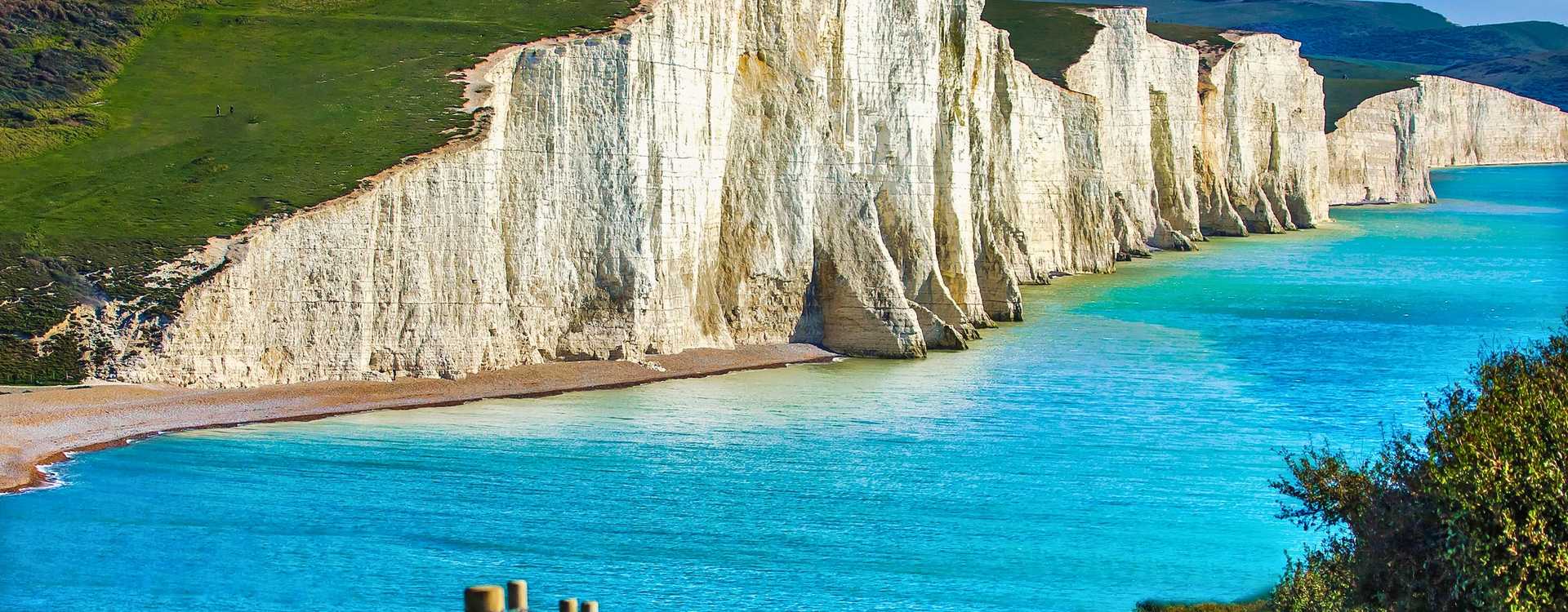 Spectacular Seven Sisters Cliffs View - Rolling Coastal Hills 2026 Scenic coastal trail path running alongside a wooden post fence with a beautiful view of the rolling Seven Sisters white cliffs